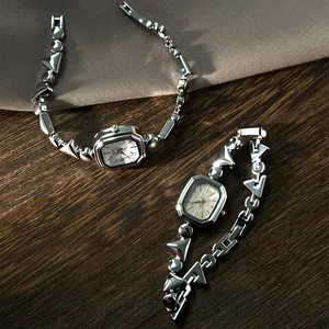 Detailed view of two elegant silver quartz watches with irregular geometric link bracelets.