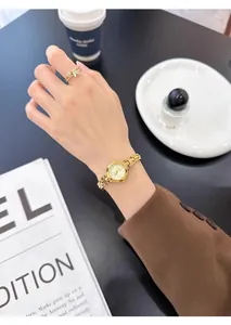 Vista detallada de un lujoso reloj de cuarzo dorado para mujer llevado en la muñeca.