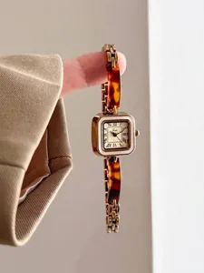 Close-up detail showing the vintage gold square dial and tortoise shell bracelet watch strap