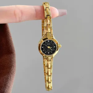 Elegante reloj de cuarzo GEDI dorado para mujer con esfera de diamante negra.