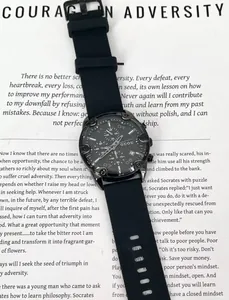Black GUOU unisex quartz chronograph watch with a silicone strap on paper background.