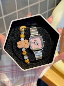 Primer plano de un lindo reloj de cuarzo cuadrado con pingüino y set de pulseras