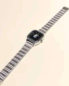 Vista detallada del reloj cuadrado plateado con esfera de pingüino y correa de acero