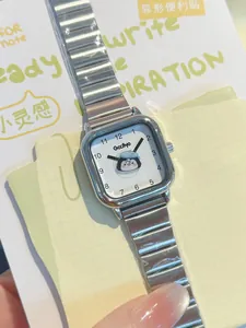 Primer plano de un reloj cuadrado plateado con esfera de pingüino y correa de acero
