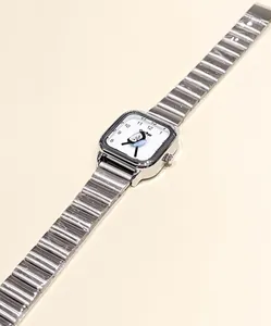 Detalle del reloj cuadrado plateado con esfera de pingüino y correa de metal fina