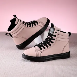 Detailed macro view of pink high-top leather fashion boots with black laces and soles