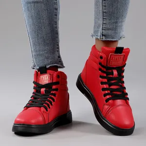 Close-up detail of red high-top casual fashion boots with black laces and rubber soles