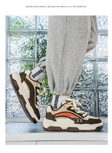 Detailweergave van stijlvolle bruin en beige chunky sneakers gedragen door een model