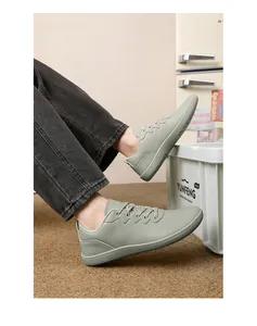 Dettaglio di scarpe da camminata a piedi nudi con punta larga in verde salvia indossate