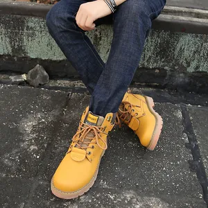 Close-up view of vintage yellow leather boots with laces on rough stone background