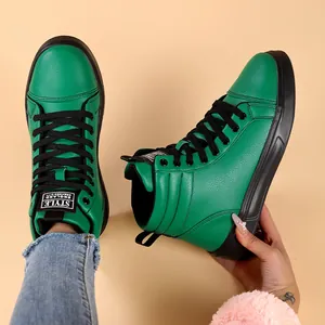 Vibrant green high-top fashion boots with black laces and textured leather finish.