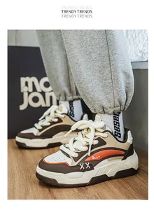 Gedetailleerd zicht op stijlvolle ademende chunky sneakers met oranje en bruin kleurblokontwerp