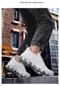 Detailweergave van witte ademende flyknit hardloopschoenen met duurzame blade-zool.
