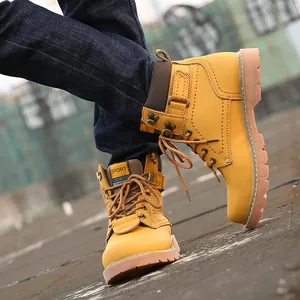 Detailed close-up of vintage yellow leather work boots for men in a street setting.