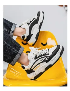 Detailopname van zwart-witte chunky sneakers op een gele stoel.