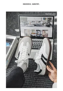 Lifestyle view of wide-toe barefoot sneakers on a carpet with a laptop and books background.