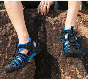 Men's blue and black outdoor sandals featuring a breathable hollow design on rocky ground