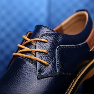 Detailaufnahme von blauem genarbtem Lederhalbschuh mit gelben Schnürsenkeln.