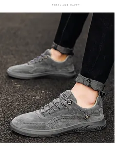 Vue détaillée de chaussures décontractées en cuir suédé gris portées sur de l'asphalte