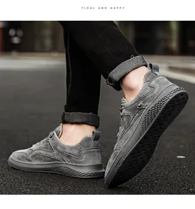Gros plan de chaussures décontractées en daim gris pour hommes sur de l'asphalte.