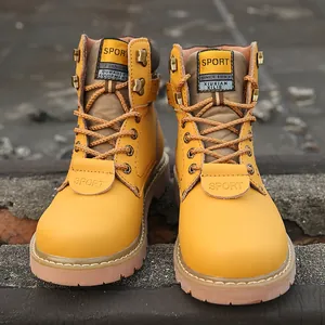 Front view detail of yellow leather outdoor boots with brown laces and metal eyelets.