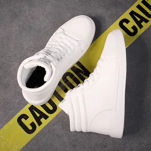 Macro view of white high-top leather boots on grey background with yellow caution tape