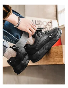 Close-up van stijlvolle zwarte chunky sneakers voor heren met ademend ontwerp aan de voeten