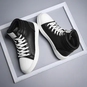 Detailed view of high-top black and white leather fashion boots in a white frame