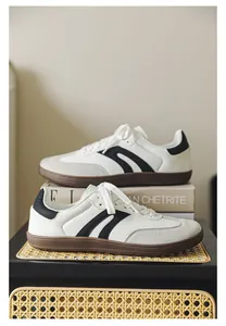 Side view of white wide-toe training sneakers with black stripes and gum soles