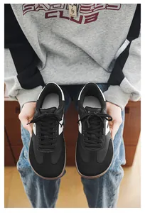 Detail shot of black barefoot wide toe box sneakers held by a person in lifestyle