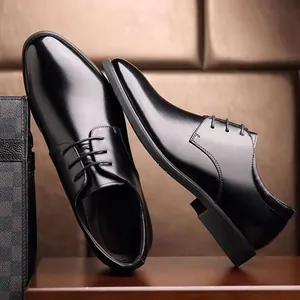 Detail of black glossy leather dress shoes with lace-up design for men's business wear
