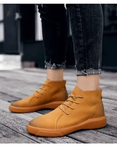 Detailed side view of stylish men's yellow leather high-top casual boots on a wooden deck