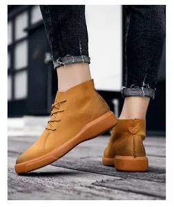Side view detail of men's mustard yellow leather high-top casual boots on a wooden deck
