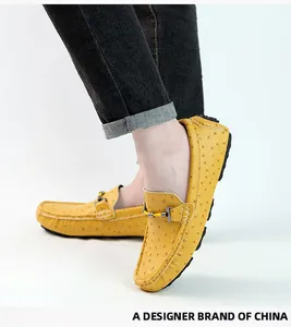 Close-up detail of stylish yellow ostrich pattern men's loafers worn by a model