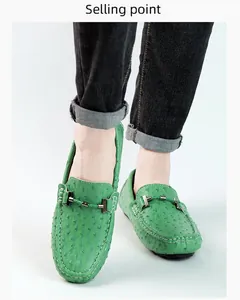 Detail of green ostrich-textured loafers with metal buckle on model