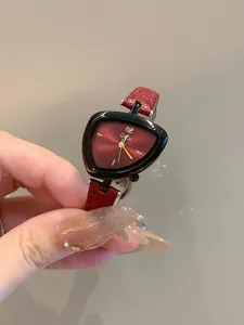 Dettaglio dell'orologio GEDI da donna con quadrante triangolare rosso e cinturino in pelle.
