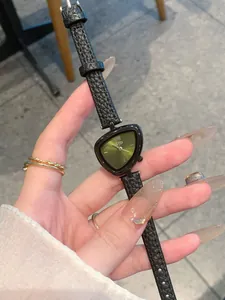 Primo piano di un orologio da donna con quadrante triangolare e cinturino in pelle nera