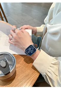 Montre élégante à cadran carré bleu portée au poignet lors d'une pause café détente