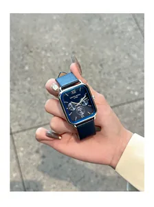 Montre à quartz rectangulaire élégante avec cadran bleu et bracelet en cuir en main
