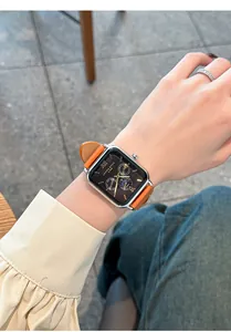 Vue détaillée d'une montre à quartz carrée avec bracelet en cuir orange au poignet