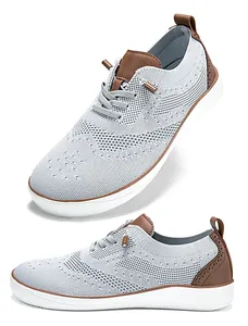 Detailed view of grey breathable knit wide-toe shoes with brown leather accents.