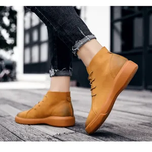 Close-up detail of yellow high-top men's leather boots worn while walking on a wooden deck