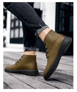 Detailed side view of premium men's olive green leather chukka boots on a rustic wooden floor