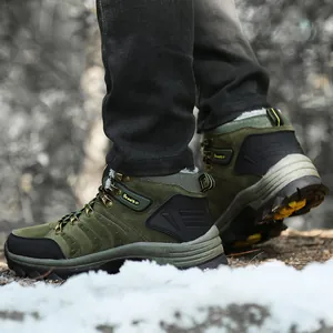 Close-up of olive green waterproof hiking boots with warm fur lining on snow.
