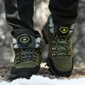 Close-up of olive green winter hiking boots with warm faux fur lining on snow ground