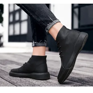 Close-up of stylish black leather ankle boots for men on a wooden deck