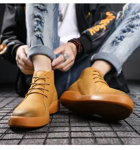Close-up detail view of stylish men's yellow leather work boots with thick gum soles