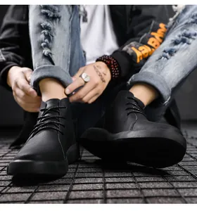Detailed close-up view of men's black pebbled leather high-top work boots with laces