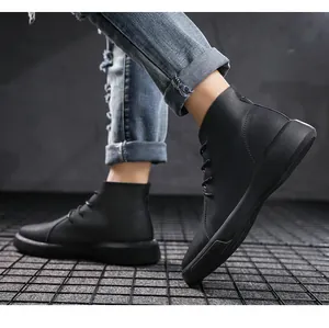 Rugged black leather high-top boots for men worn with distressed denim in industrial set