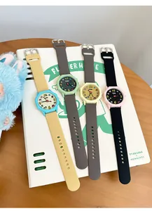Close-up of colorful Dopamine-style silicone watches on a branded stationery notebook